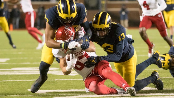 Michigan safety Tyree Kinnel, left, and wide receiver Eddie McDoom tackle Indiana's Mitchell Paige during a punt return in the third quarter.