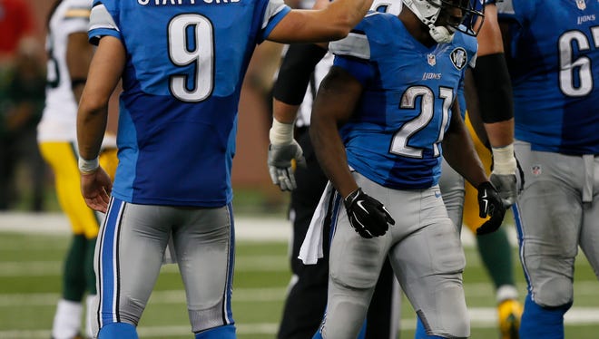 Detroit Lions Matthew Stafford past Reggie Bush on the helmet after a solid gain on a run in the second half of their 19-7 win over the Green Bay Packers in Detroit on Sunday, September 21, 2014.