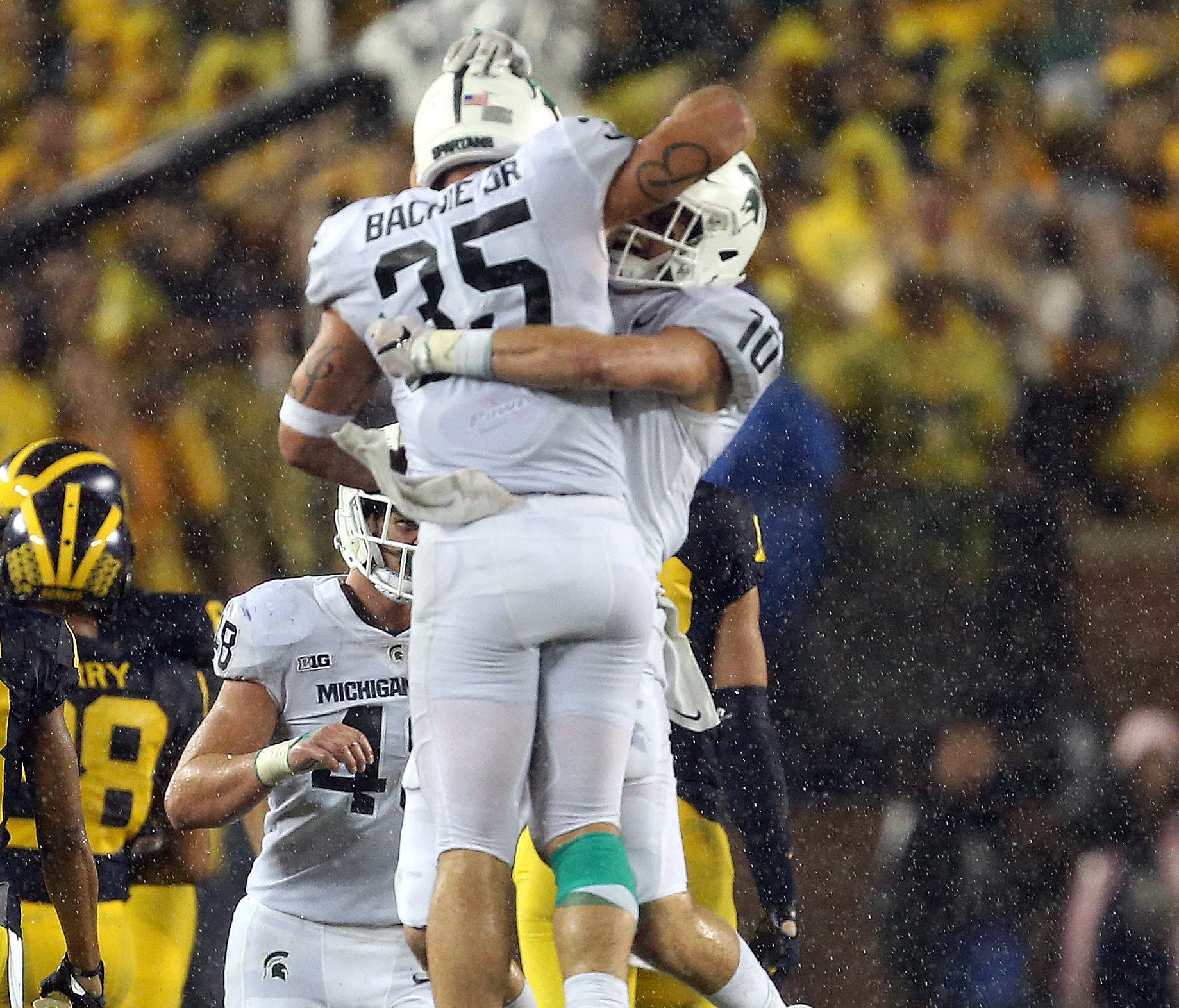 Michigan State Spartans linebacker Joe Bachie (35) and Michigan State Spartans safety Matt Morrissey (10) celebrate a interception during the second half of a game at Michigan Stadium.