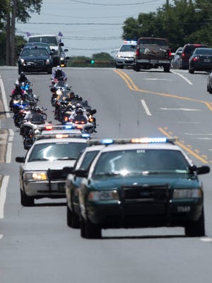 A motorcade travels down Cervantes Street on June 16, 2017, after the funeral for Naomi Jones.