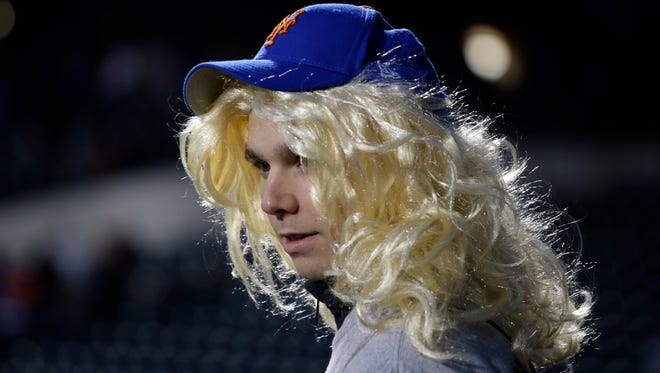 A fan wears a wig before Game 4 of the Major League Baseball World Series between the New York Mets and Kansas City Royals Saturday, Oct. 31, 2015, in New York.