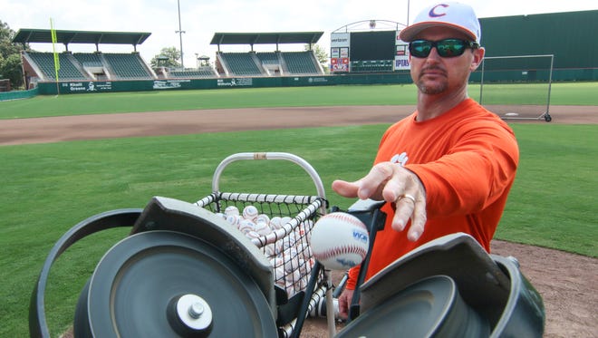 Clemson head coach Monte Lee (18) inserts a baseball in a pitching machine during the first fall practice Sept. 16 at Doug Kingsmore Stadium in Clemson.