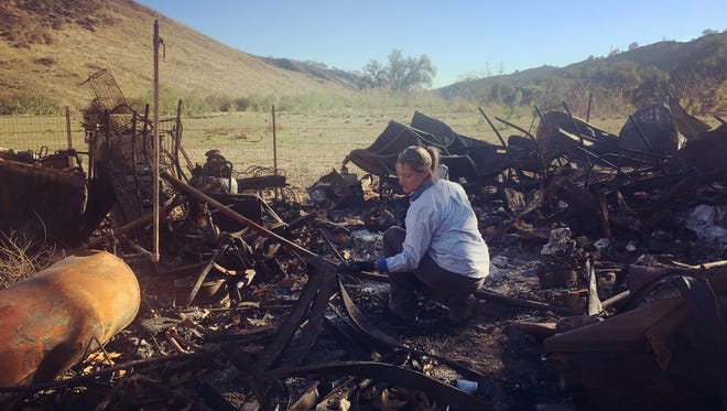 Stacy Hyatt sorts through the remains of her home in Wheeler Canyon after the Thomas Fire destroyed the property she was renting.