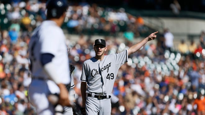 Chicago White Sox starting pitcher Chris Sale (49) points to the outfield while talking to Detroit Tigers designated hitter Victor Martinez on Wednesday, Sept. 24, 2014.