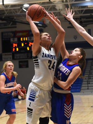 Zanesville's Mayson Hutzel goes up in the lane against Alicia Alexander during the Lady Devils' 50-35 win against visiting West Holmes on Wednesday at Winland Memorial Gymnasium. 