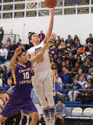 Bloomfield's Damion Sanchez beats Kirtland Central's Jariah Setzer on a layup on Saturday at Bobcat Gym in Bloomfield.