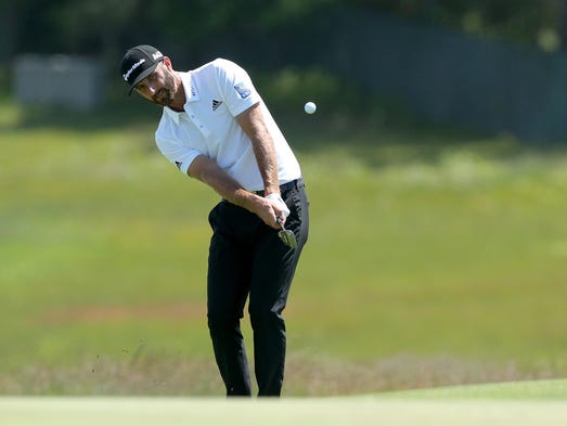 Dustin Johnson chips onto the 2nd green from the fairway