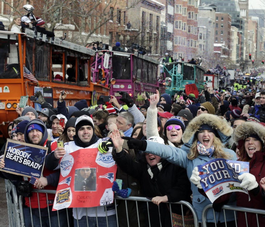 New England Patriots fans cheer as the team passes by in a procession of duck boats during a parade in Boston Wednesday, Feb. 4, 2015, to honor the Patriots' victory over the Seattle Seahawks in Super Bowl XLIX Sunday in Glendale, Ariz.