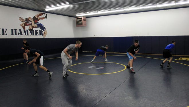 Regina wrestlers practice in the school's wrestling room. One of them, Jared Brinkman, is 38-0 entering this week's state tournament.