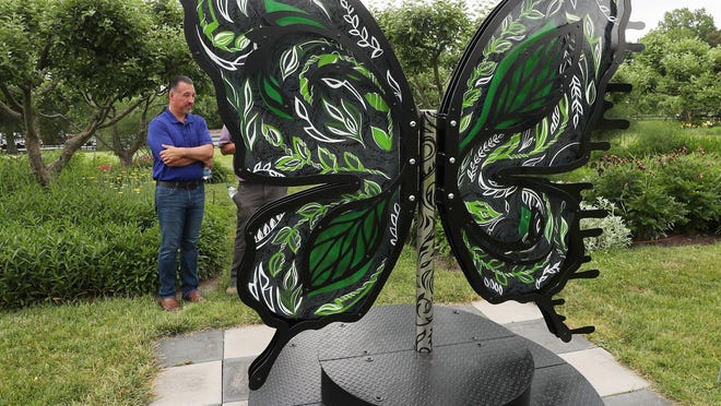 Sean Joyce, Stan Hywet, president and CEO, looks at artist Kimmy Henderson's "Bipolar Butterfly" as he talks about the Winds of Change show at Stan Hywet Hall and Gardens.