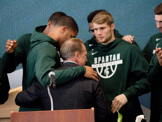 Spartans head coach hugs his players after speaking