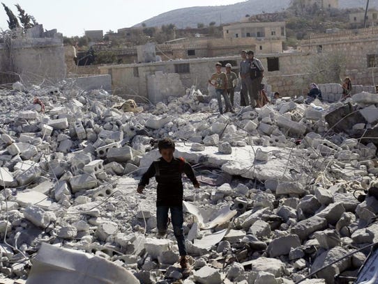 Residents inspect damaged buildings in what activists