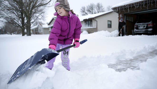 Elliot Kriewaldt, 7, helps her mother, Amanda Kriewaldt, shovel their Grand Chute driveway Tuesday after winter storms swept through the area,