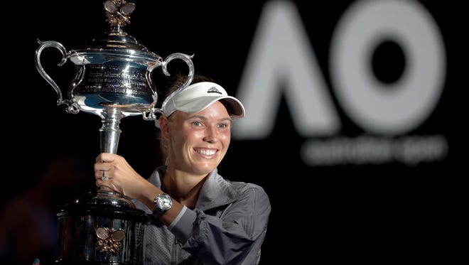 Caroline Wozniacki holds her trophy aloft after defeating Simona Halep in the women's singles final at the Australian Open on Saturday.