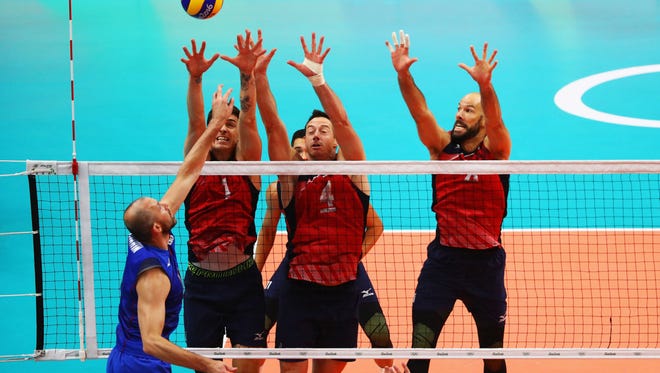From  left, Matthew Anderson, David Lee and Reid Priddy put up a wall against Russia's Sergey Tetyukhin. Priddy ended his indoor volleyball career with a bronze medal.