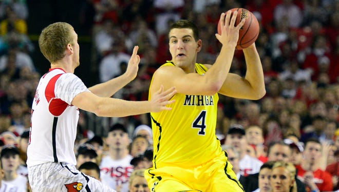 Michigan forward Mitch McGary (4) looks to pass against Louisville guard Tim Henderson (15) during the first half of 2013 NCAA tournament championship game in Atlanta.
