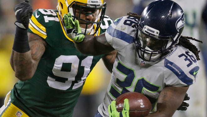 Green Bay Packers linebacker Jayrone Elliott (91) tackles Seattle Seahawks running back Alex Collins after a 13-yard reception.