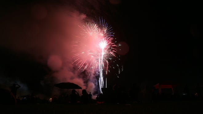 People watch the fireworks show during the third annual Firefighter's Freedom Festival at the McKellar-Sipes Regional Airport on Monday, July 4, 2016.