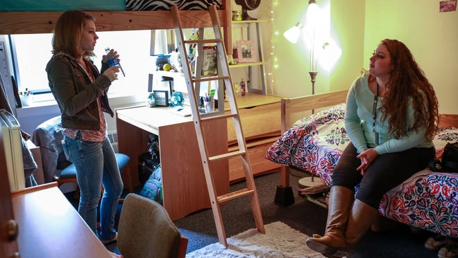 Mariah Whitelock, 18, of Riverview, right, a freshman at Oakland University in Rochester, chats with her roommate,
Stephanie Campbell, 18, of Ortonville in their  dorm room on Friday, Oct. 30, 2015.