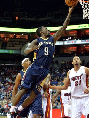 New Orleans Pelicans' Russ Smith, center, goes in for a layup past the defense of Miami Heat's Chris Johnson during the fourth quarter of an NBA basketball preseason game in Louisville, Ky., Saturday, Oct. 4, 2014. New Orleans defeated Miami 98-86. (AP Photo/Timothy D. Easley)