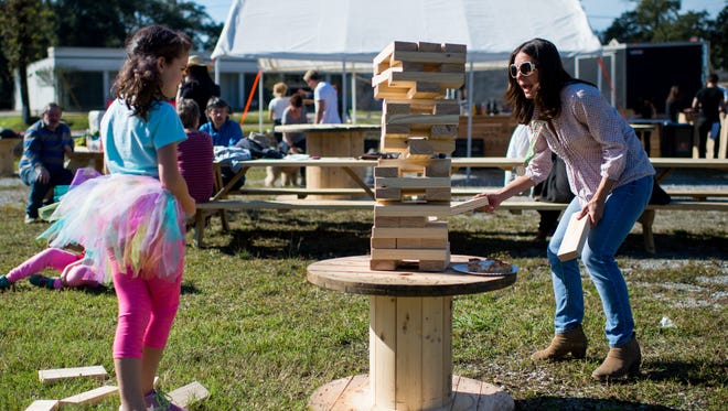 Camille Regard and her mother Olivia Regard play a game at Olympic Grove in Lafayette, La., Saturday, Dec. 5, 2015. The pop-up beer garden is located at the corner of West St. Mary and St. Landry Streets in Lafayette. 