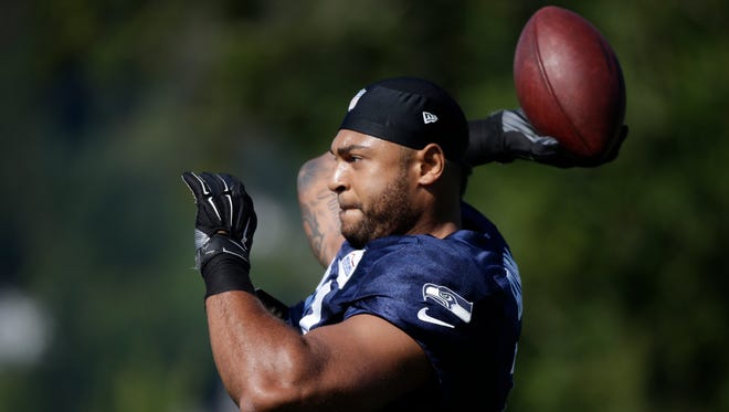 Seattle Seahawks' Garry Gilliam tosses a ball at an NFL football training camp Thursday, Aug. 6, 2015, in Renton, Wash.