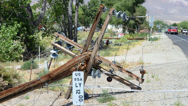 This power pole on the south side of Nevada 95A in Yerington at the Green Acres intersection snapped, with its lines laying near the roadway surface, and two other power poles in the background, laying to the left, also broke after a semi-trailer rig, far background, white, pulling into a driveway snagged power lines, snapping the poles to the east Wednesday morning.