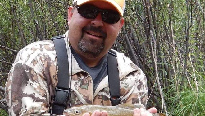 New Mexico outdoorsman Jason Amaro holds a Gila River Trout before releasing it back into the water.