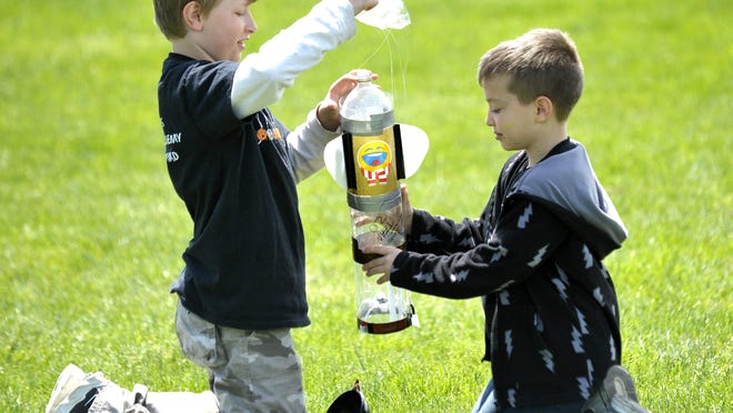 Mt. Clemens Montessori Academy third grader Stephen Krause, left, 9, of Mount Clemens, and fifth grader Alex Cartagena, right, 10, of Clinton Township, repack their water bottle rocket parachute before firing it again.