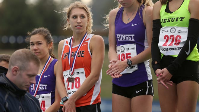 Sprague's Kaylee Mitchell receives her fourth place medal in the OSAA Class 6A State Championship girls cross country meet at Lane Community College in Eugene on Saturday, Nov. 4, 2017.
