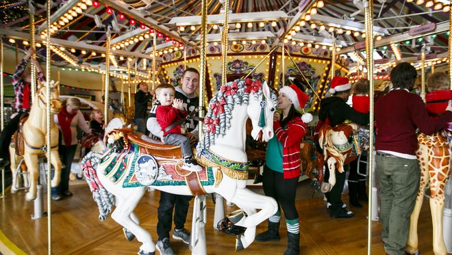 Coleton Walling, 2, claps as he rides the Riverfront Carousel with parents Zach Walling, center, and Nyssa Hicks, right, on Christmas Eve, Saturday, Dec. 24, 2016. The carousel will offer free rides from noon to 4 p.m. on Dec. 25, with a suggested donation to support Marion-Polk County Food Share.