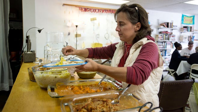 The Rev. Shannon Spencer helps herself to a lunch made up of rescued food donated from local restaurants Thursday April 5, 2016 at 12 Baskets cafe in West Asheville.