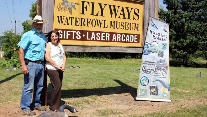 In this Aug. 8, 2014 photo, Craig and Nichol Swenson pose near the sign for Flyways Waterfowl Museum in Baraboo, Wis. Nichol and Craig Swenson, who opened Flyways Waterfowl Museum near the north shore entrance to Devil's Lake State Park last summer, are living out their mission of conservation.