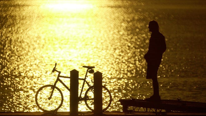 A University of Vermont junior from Southampton NY majoring in English and Philosophy, takes a break from his studies to ride his bike down to Burlington's Waterfront Park and enjoy the sunset in 2002 (from the photo archive)