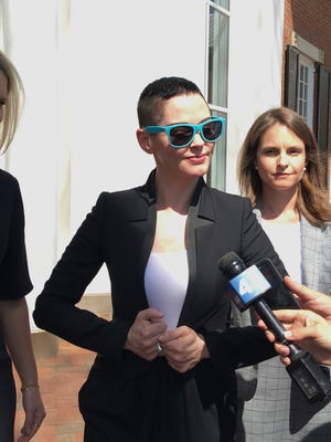 Actress Rose McGowan, flanked by lawyers Jennifer Robinson, left, and Jessica Carmichael, right, outside the Loudoun County courthouse on May 3, 2018, in Leesburg, Va.