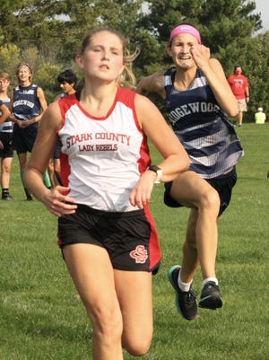 Stark County's Paige Rewerts holds off a late charge from Ridgewood's Kira Messerly in a race for seventh place on Wednesday at The Dunes.