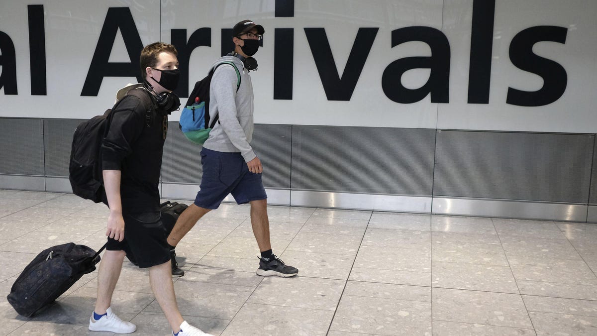 Passengers arrive at Heathrow Airport in London July 26. Many travelers across the world are finding themselves stuck due to the coronavirus pandemic.