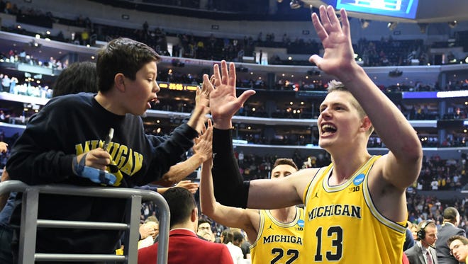 Michigan forward Moritz Wagner (13) reacts with fans as he exits the court after the win. UM defeated Texas A&M, 99-72, Thursday to advance to an Elite Eight matchup against Florida State  Saturday.