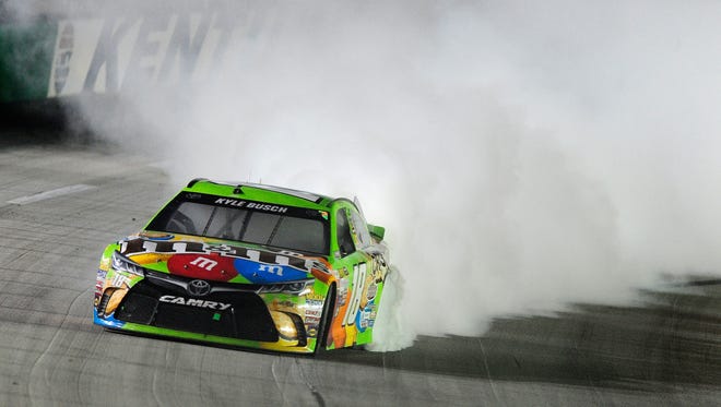 Kyle Busch celebrates winning the NASCAR Sprint Cup Series Quaker State 400 presented by Advance Auto Parts at Kentucky Speedway on July 11, 2015 in Sparta, Kentucky.