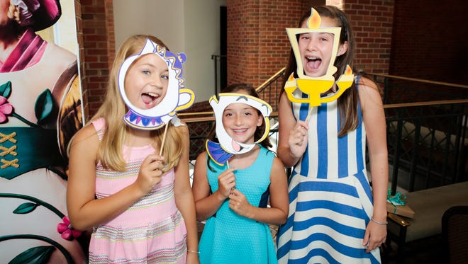 From left, Camilla Loard, Caroline Mastin and Josie Aronov peep through Beauty and the Beast-inspired handheld masks during a pre-party hosted at the Alabama Shakespeare Festival.