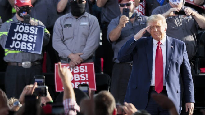 President Donald Trump salutes the crowd during the "Fighting for the American Worker" rally on Monday at the Wright Bros. Aero Hangar at the Dayton International Airport in Vandalia.