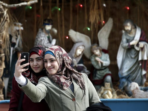 Muslim women take a selfie in front of the giant Christian