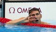 Michael Phelps (USA) holds up four fingers, for his