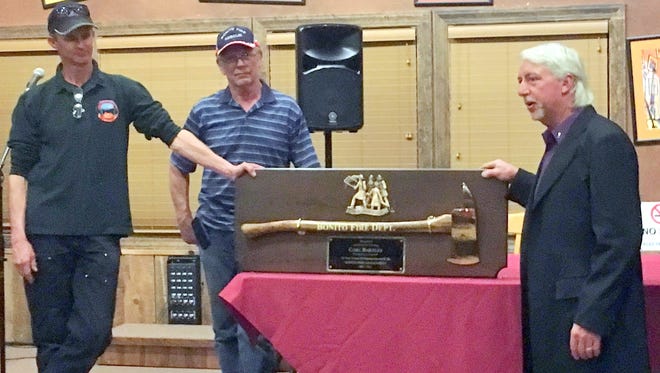 Carl Bartley, right, is presented with a custom ax engraved with his name in recognition for his 13 years of service as chief of the Bonito Volunteer Fire Department. Longtime Assistant Chief Robby Hall, left, and incoming Chief Rick Hall presented the ax and plaque at the group's annual banquet.