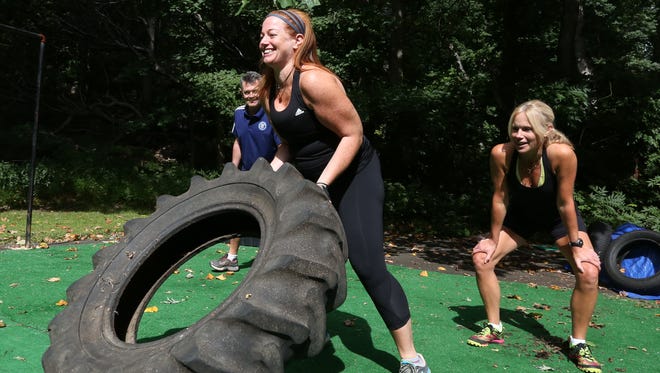 Katie Green of South Nyack, front, and Ed Mooney of Valley Cottage work out with fitness trainer Beth Chamberlin at Nyack Boot Camp in Upper Grandview Sept. 21, 2015.