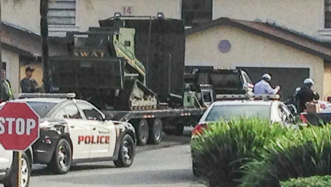 Police use a large SWAT tactical vehicle from Orange County during a standoff with an armed man at Coral Gardens apartment complex in Melbourne