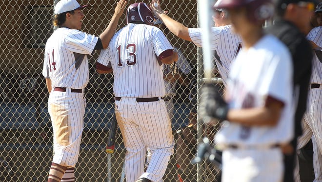 Rancho Mirage High School's Christian Sadler is congratulated after scoring a run against Desert Mirage High School during their game at on April 12, 2017. 