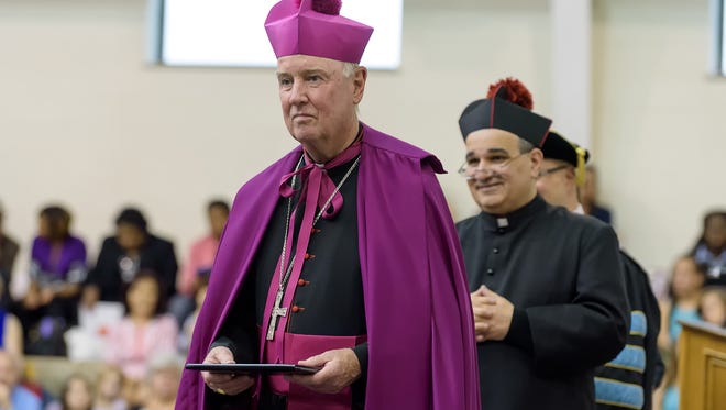 Bishop Malooly and Father James Lentini participate in a graduation ceremony at St. Thomas More Academy.
