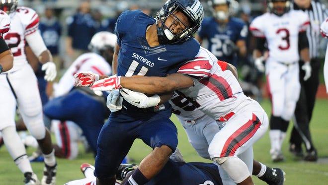 Southfield running back Adrian Carter is hit hard by Oak Park defender John Kelly during their meeting in October.