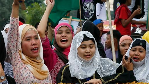 FILE - In this Wednesday, Feb. 3, 2016 file photo, Filipino Muslims shout slogans during a protest at the Philippine Congress in suburban Quezon city, northeast of Manila, Philippines because they believe the Philippine Congress has run out of time to pass under the current president's term a Muslim autonomy bill that aims to peacefully settle a decades-long Muslim rebellion in the south. The Philippine government and Muslim rebels have extended the stay of international cease-fire monitors at their first meeting since their peace pact stalled amid fears of fresh fighting. In their joint statement issued Friday, Feb. 12, government negotiator Miriam Coronel-Ferrer and her rebel counterpart, Mohagher Iqbal, expressed disappointment over Philippine Congress's failure to pass a Muslim autonomy bill that's required under a 2014 peace accord that ended decades of fighting in the southern Philippines. (AP Photo/Bullit Marquez, File)